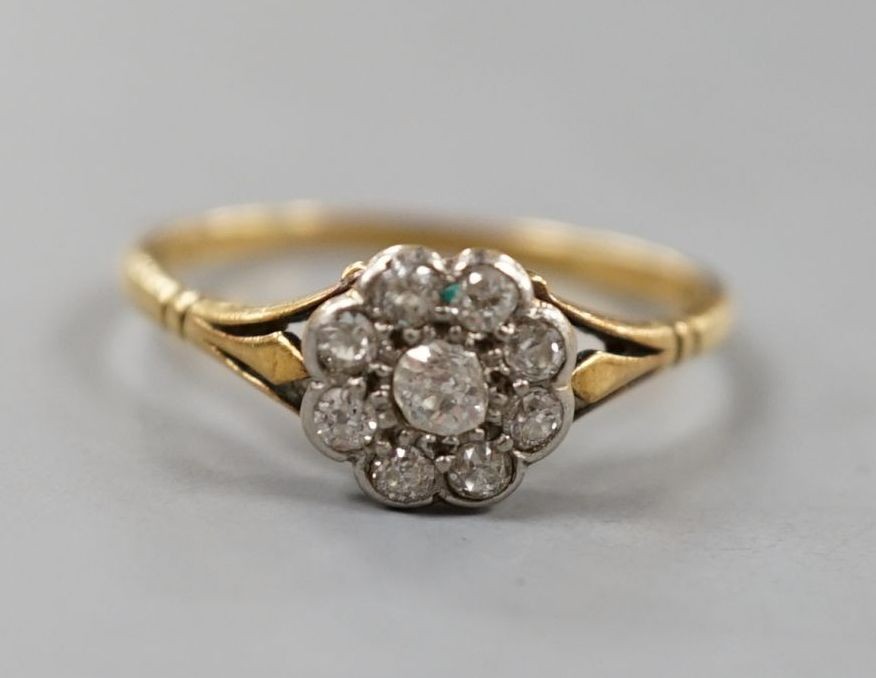 A yellow metal and nine stone diamond set flower head cluster ring, size Q